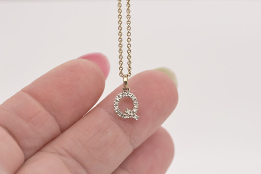 Letter Q diamond in white gold with yellow gold bale