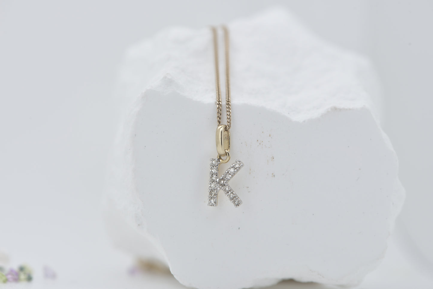 Letter K diamond in white gold with yellow gold bale
