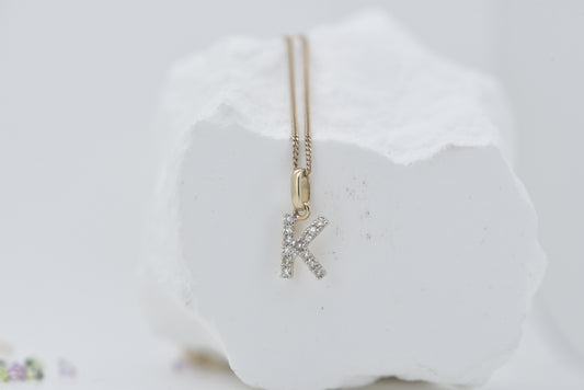 Letter K diamond in white gold with yellow gold bale