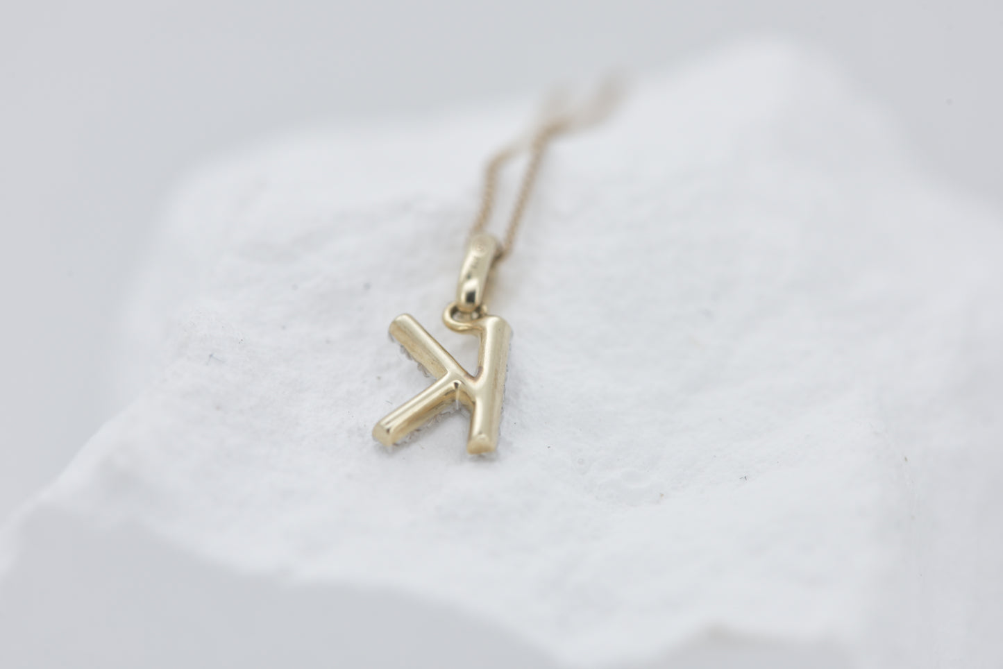 Letter K diamond in white gold with yellow gold bale