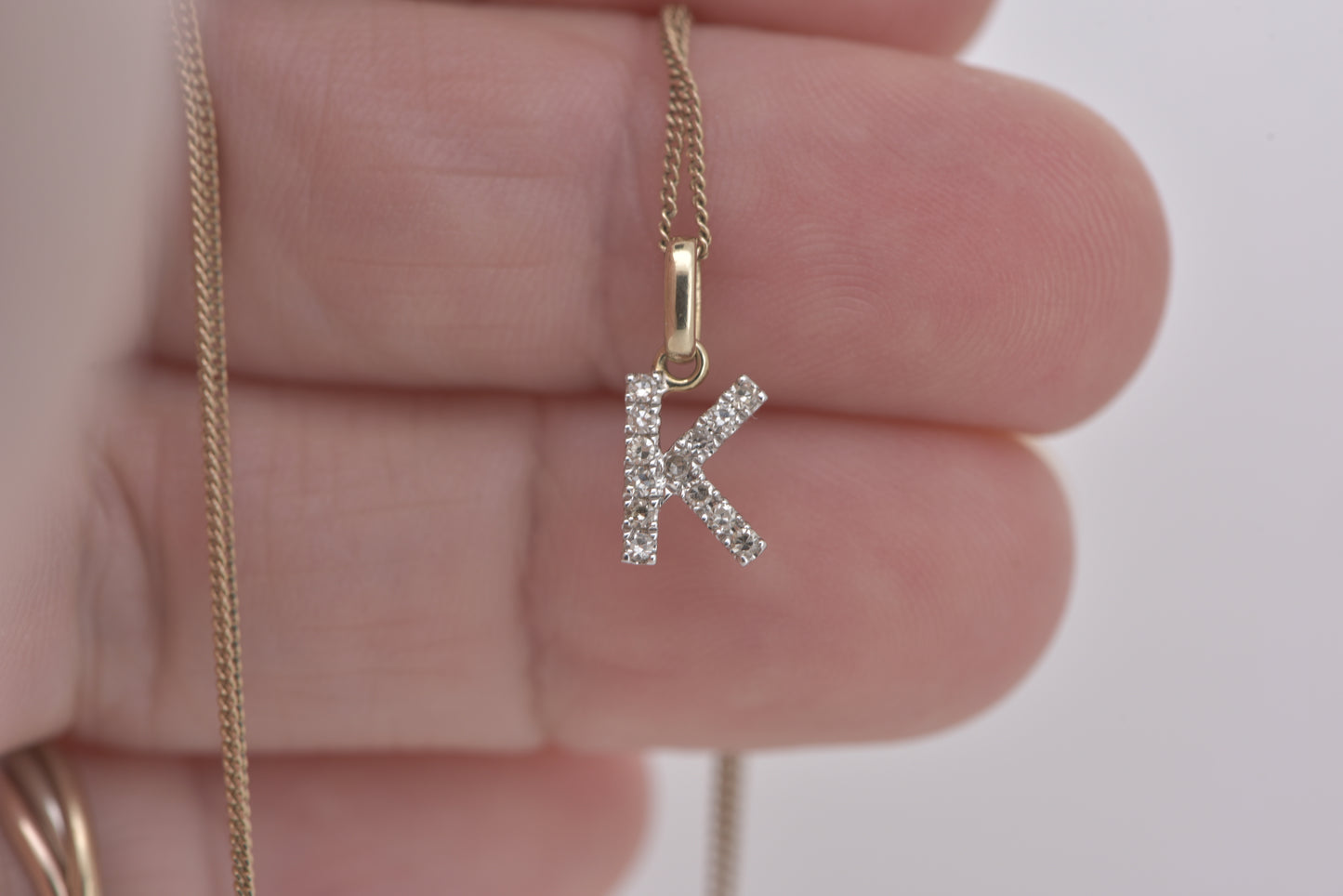 Letter K diamond in white gold with yellow gold bale