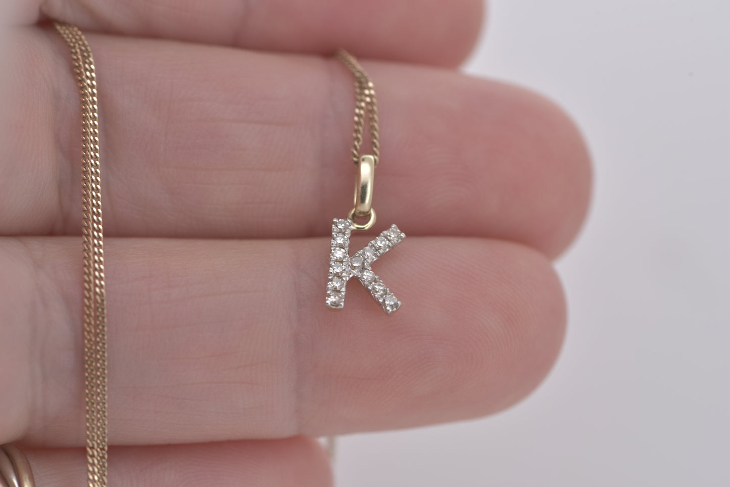 Letter K diamond in white gold with yellow gold bale